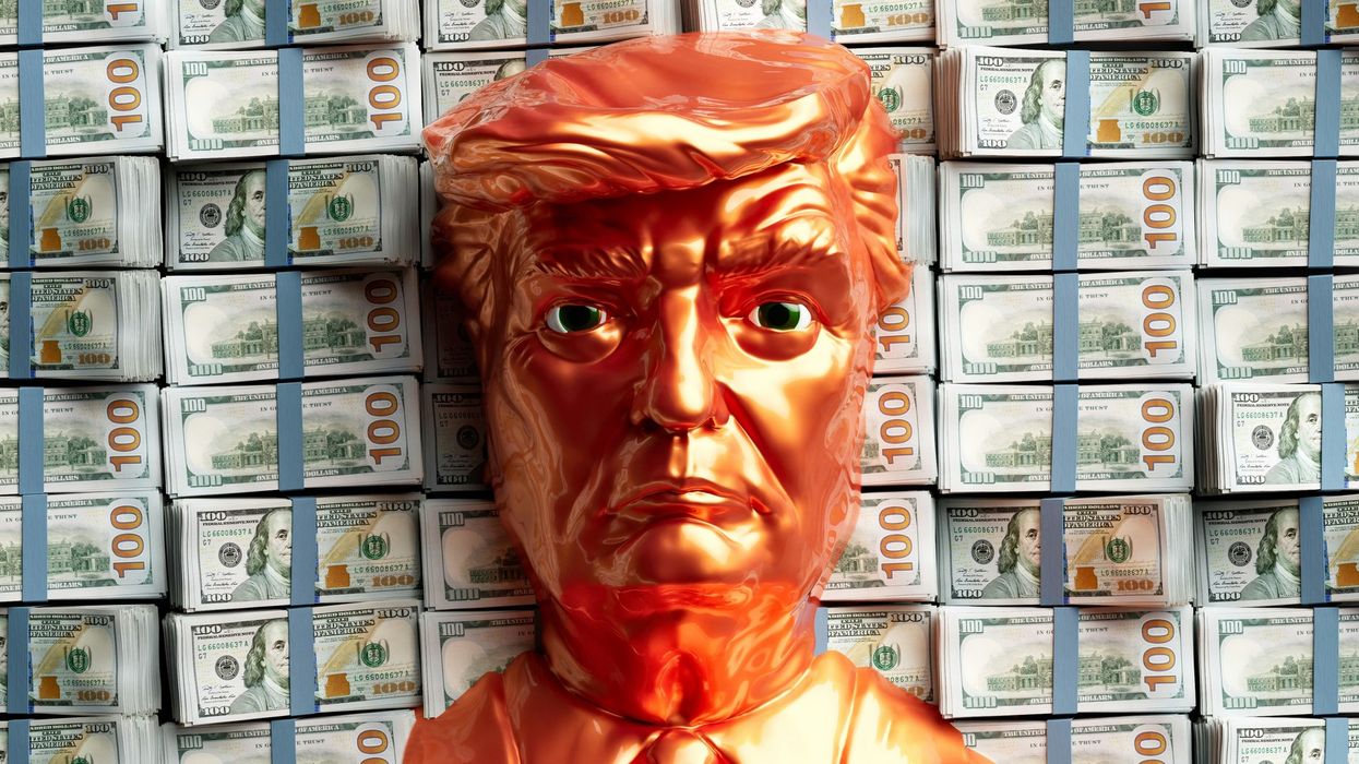 a figurine face of Donald Trump on top of $100 bills, money