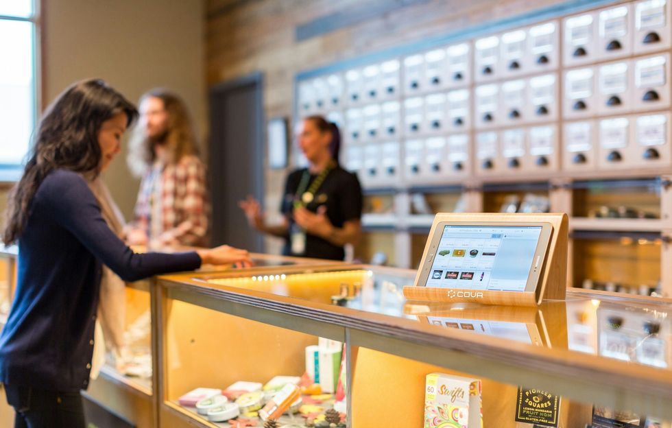 a woman standing at a counter in a legal cannabis store