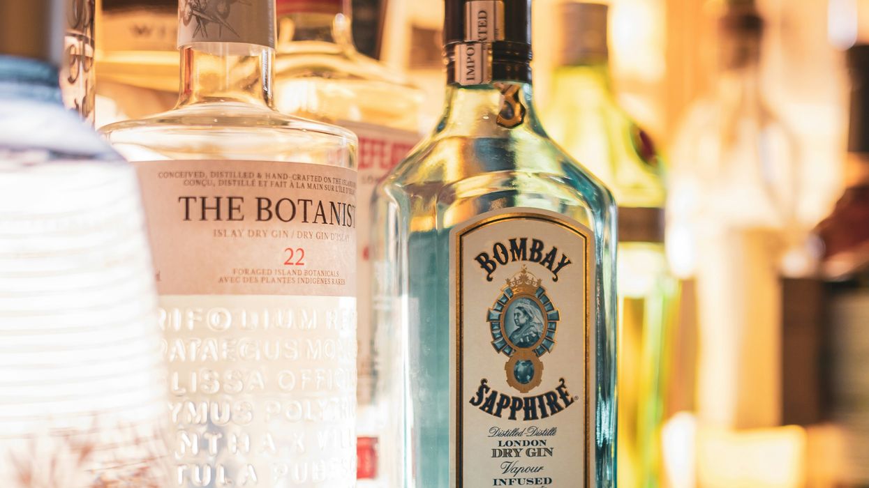 bombay sapphire gin, miscellaneous bottles of spirits behind a backlit bar