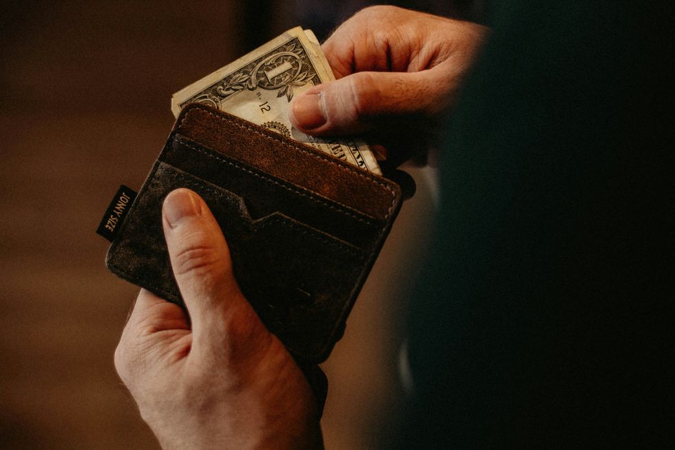 image of a man pulling cash from his wallet