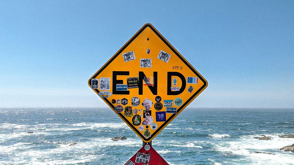 image of California traffic road sign that says - END - at edge of cliff overlooking Pacific Ocean