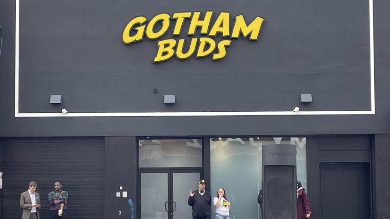 image of Gotham Buds storefront in Harlem, with people standing on sidewalk outside.